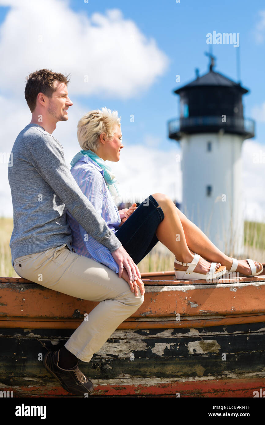 Paar beim Romantikurlaub im deutschen Nordsee Strand Düne vor Leuchtturm Stockfoto