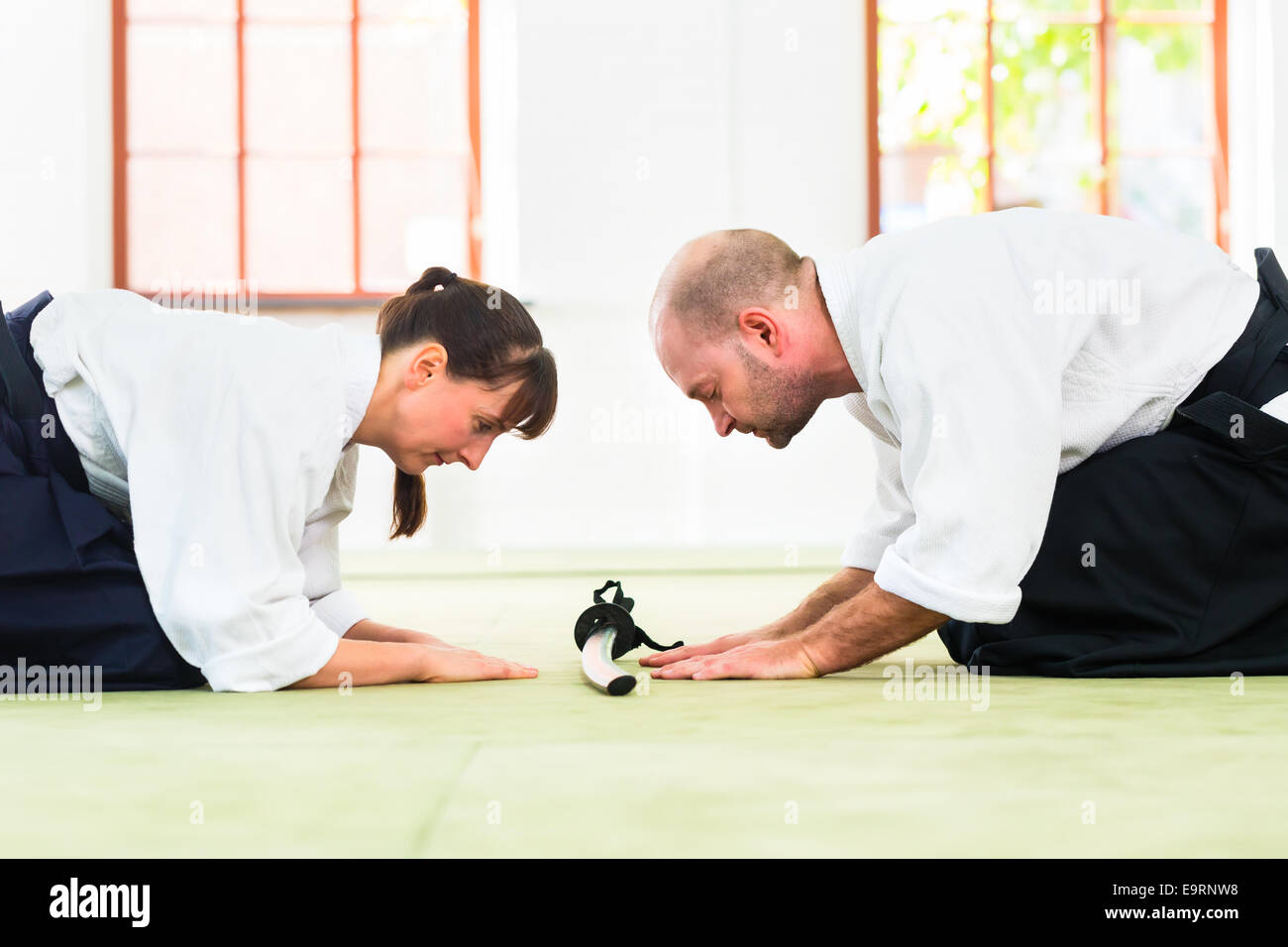 Mann und Frau nehmen Sie einen Bogen um Aikido-Kampfkunst-Schule zu begrüßen Stockfoto