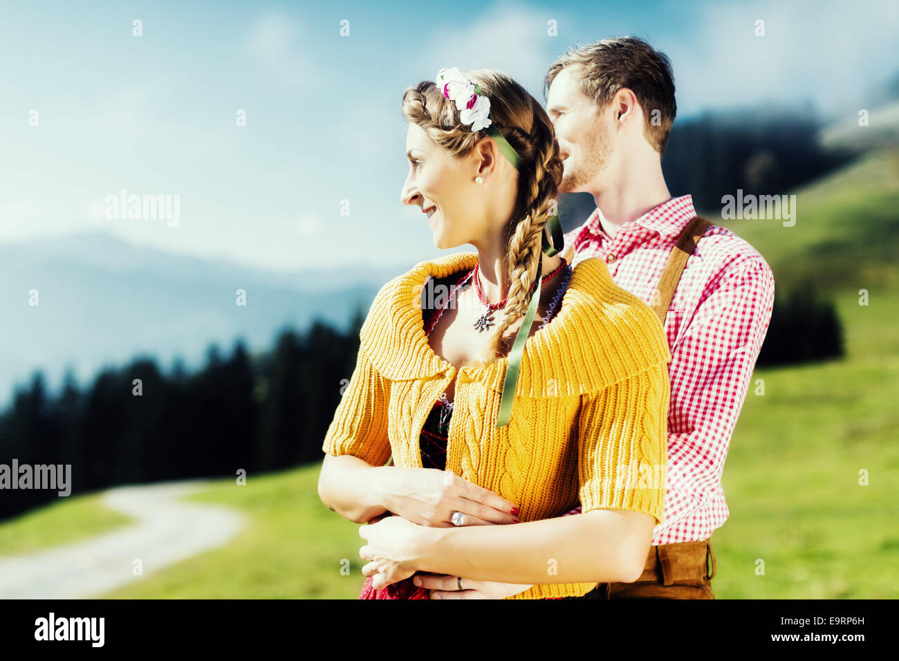 Paar in Tracht auf Alp Berggipfel im Urlaub Stockfoto