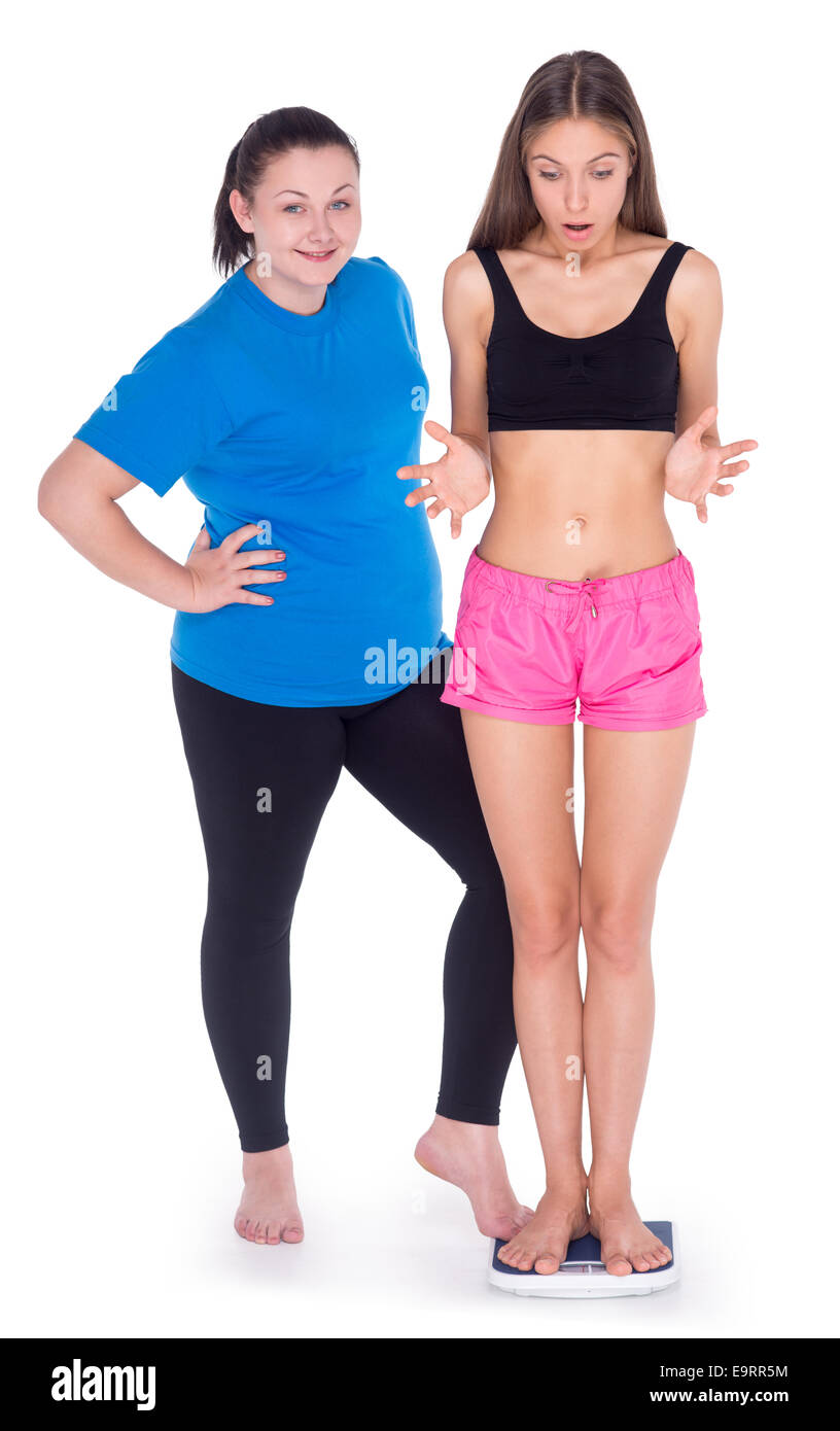 Fun Bild der übergewichtigen Frau entmutigend dünne junge Frau steht auf wiegt und Messung, isoliert auf weiss Stockfoto