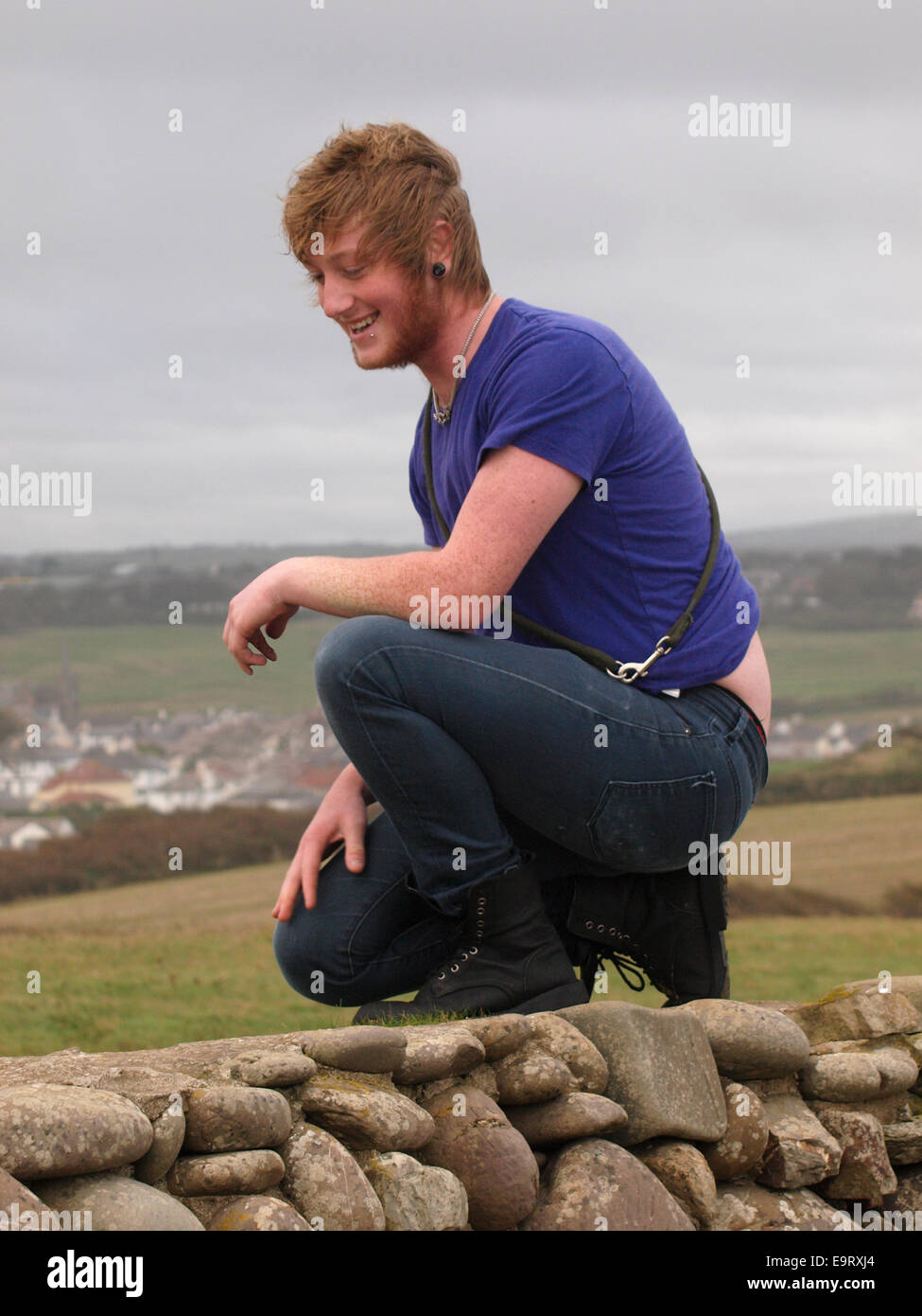 Young Adult Mann auf einem Knie, Bude, Cornwall, UK Stockfoto