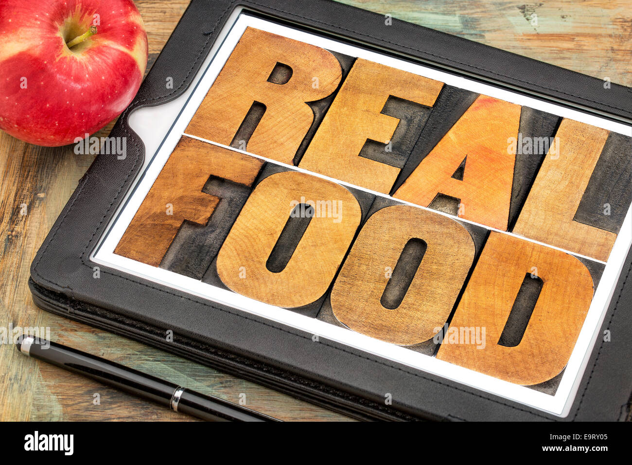 gesunder Lifestyle-Konzept - richtiges Essen, Text in Vintage Buchdruck Holzart auf einem digitalen Tablet mit einem frischen Apfel Stockfoto