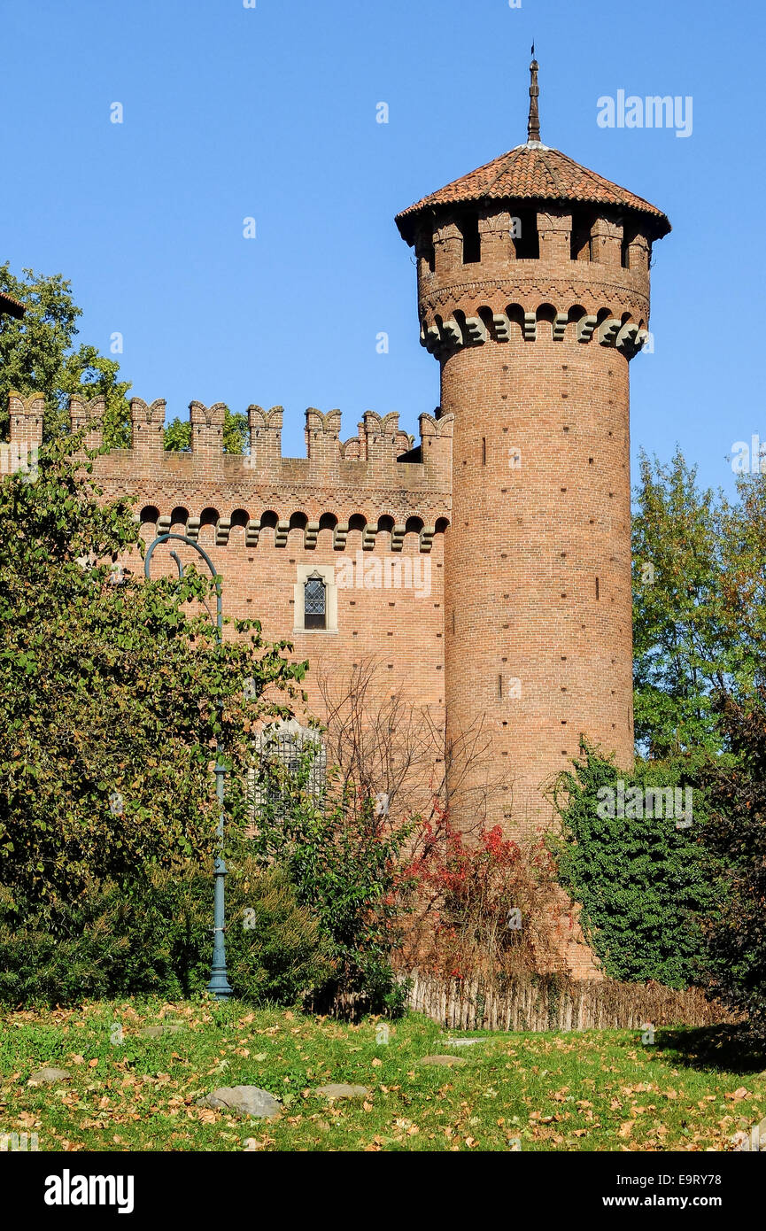 Der Turm der mittelalterlichen Burg im Valentino Park, Turin (Italien), umgeben von Vegetation vor dem Hintergrund des blauen Himmels Stockfoto