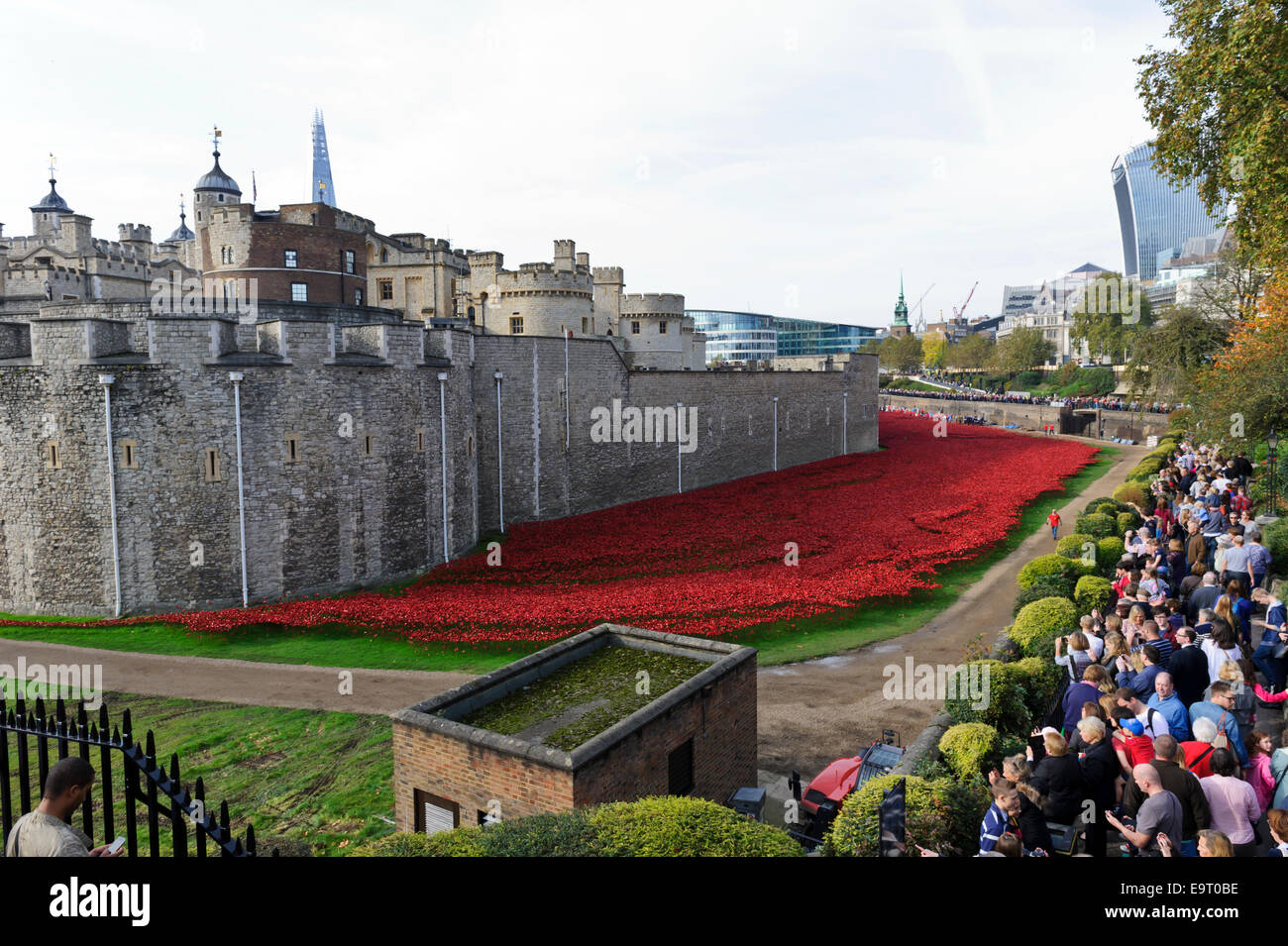 Besucher bewundern die Anzeige der Mohn außerhalb der Mauer des Tower of London, England, Vereinigtes Königreich. Stockfoto