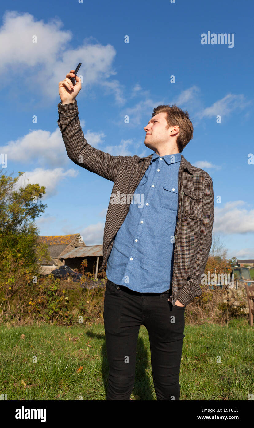 Ein Teenager auf der Suche nach einer Handy-Signal in ländlicher Umgebung in Großbritannien Stockfoto