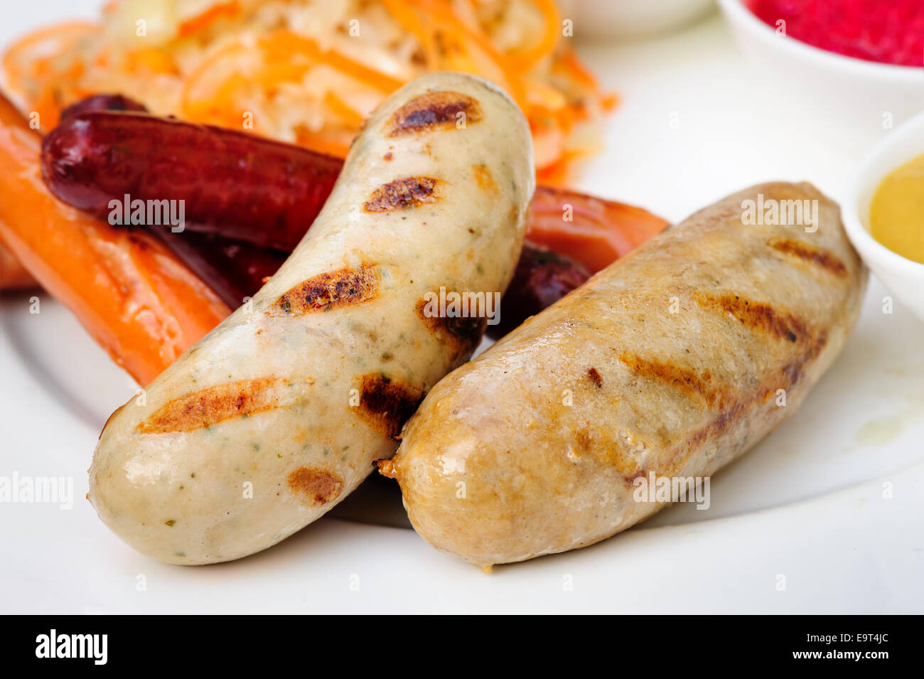 Deutsche Bratwurst mit Kraut und Saucen Stockfoto