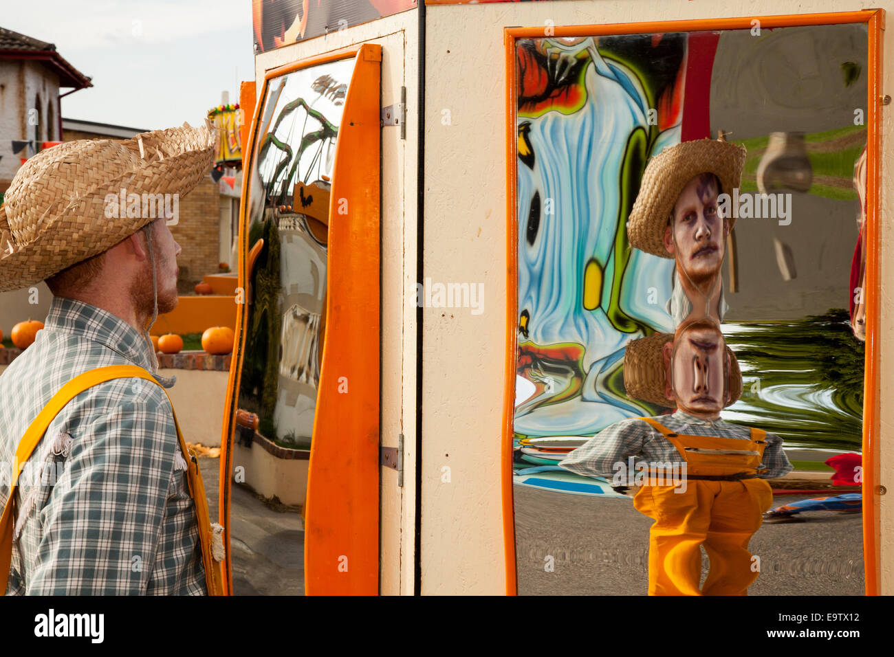 Verzerrte Portait des Menschen in Strohhut in gebogenen Spiegeln reflektiert; Spaß und interessante reflektierte Bilder in verzerrenden Vorderseite konvex & konkaven Spiegel geben repetitive Reflexionen; eine optische Illusion in einem Funhouse Spiegel. Das lustige Gesicht verzerrte Person Reflexionen des Themas mit einem gebogenen Spiegel ist eine traditionelle Quelle der Unterhaltung in der Messe Hall of Mirrors. Stockfoto