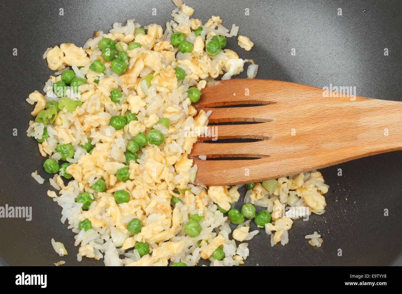 Nahaufnahme von Ei gebratener Reis in einer Antihaft-Pfanne mit einem Holzspatel Stockfoto