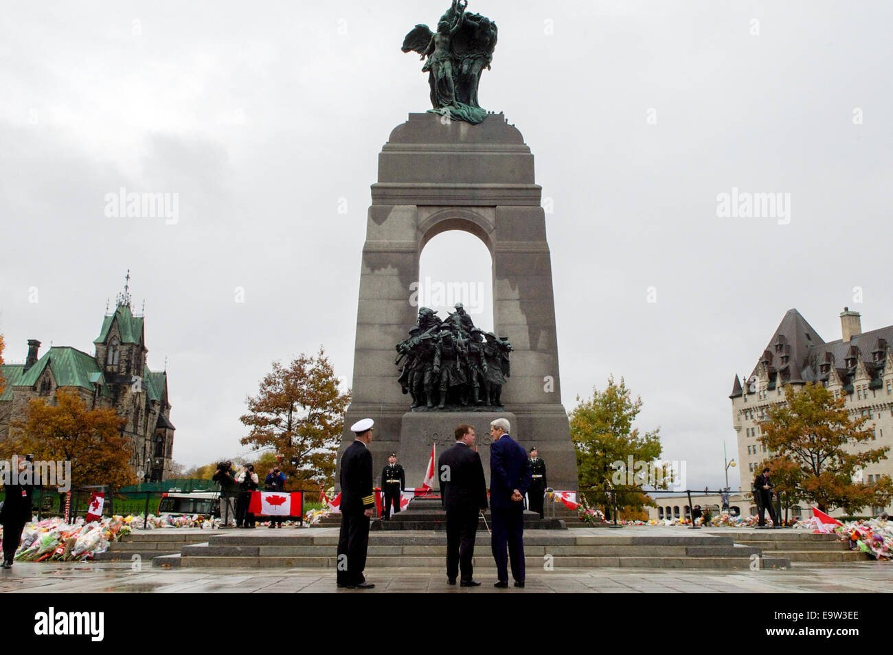 US-Außenminister John Kerry, kanadischen Außenminister John Baird und US Marine-Attaché, Captain Charles J. Cassidy, stehen nach der Verlegung eines Kranzes am Grab des unbekannten Soldaten während einer Zeremonie am National War Memorial in Ottawa, Kanada, auf Stockfoto