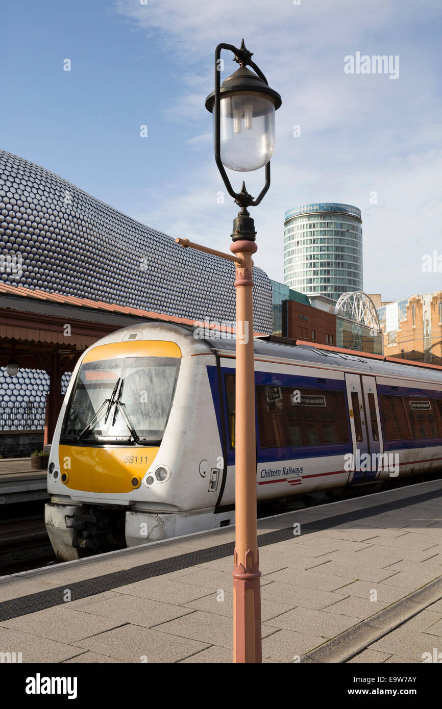 Chiltern Railways Zug wartet am Bahnsteig in Birmingham Moor Street Station, hinter, Selfridges, Rotunde und die Stierkampfarena Stockfoto