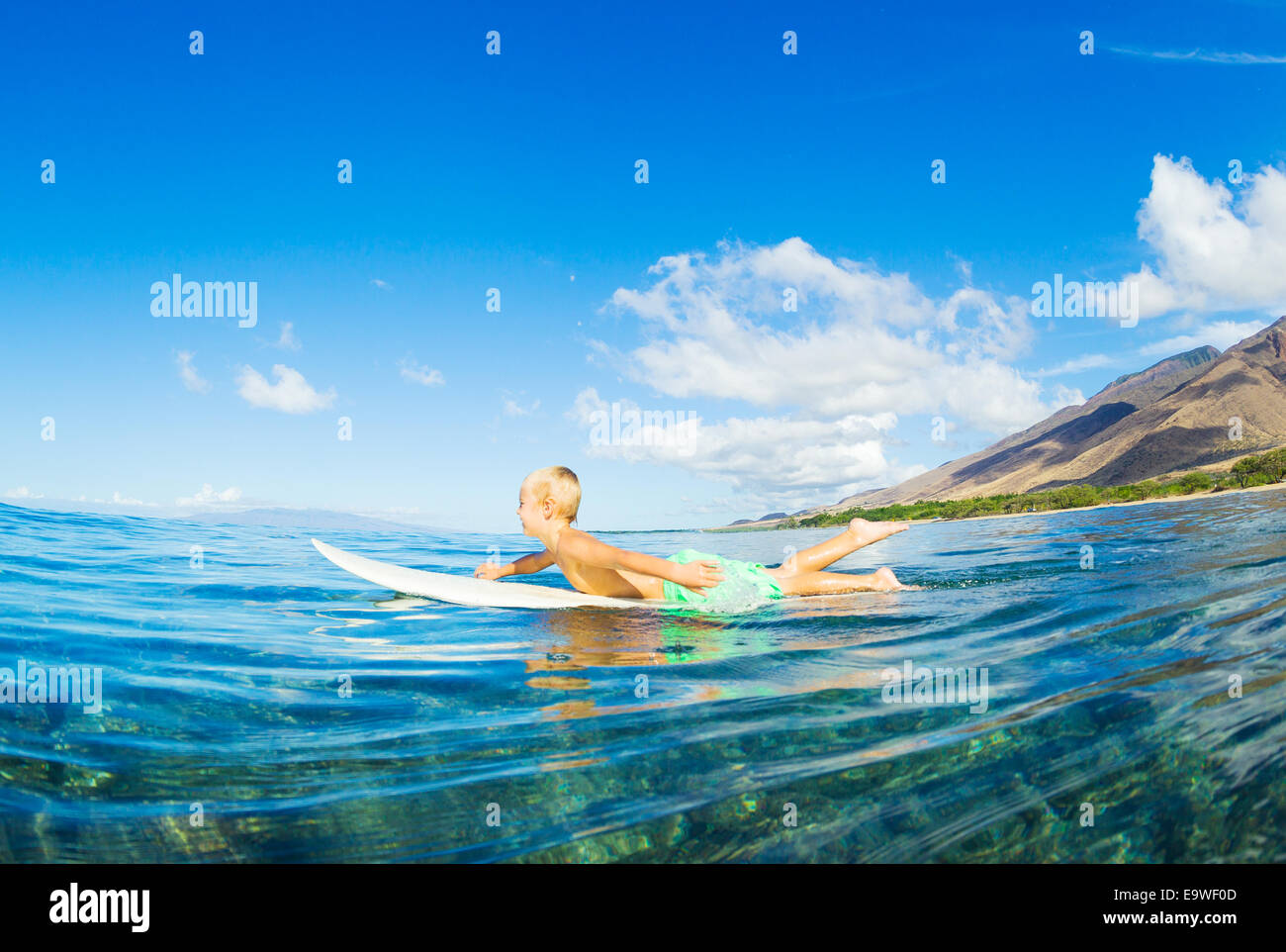 Young Boy Surfen, Paddeln Wellen Stockfoto