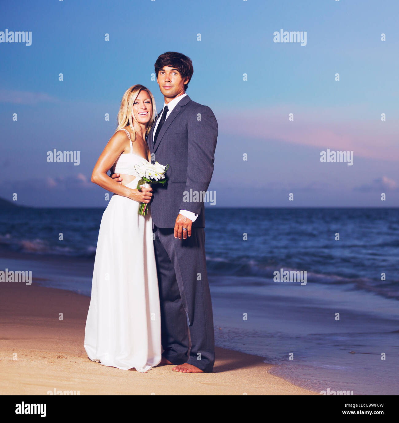 Schöne Hochzeitspaar, Braut und Bräutigam am Strand bei Sonnenuntergang Stockfoto
