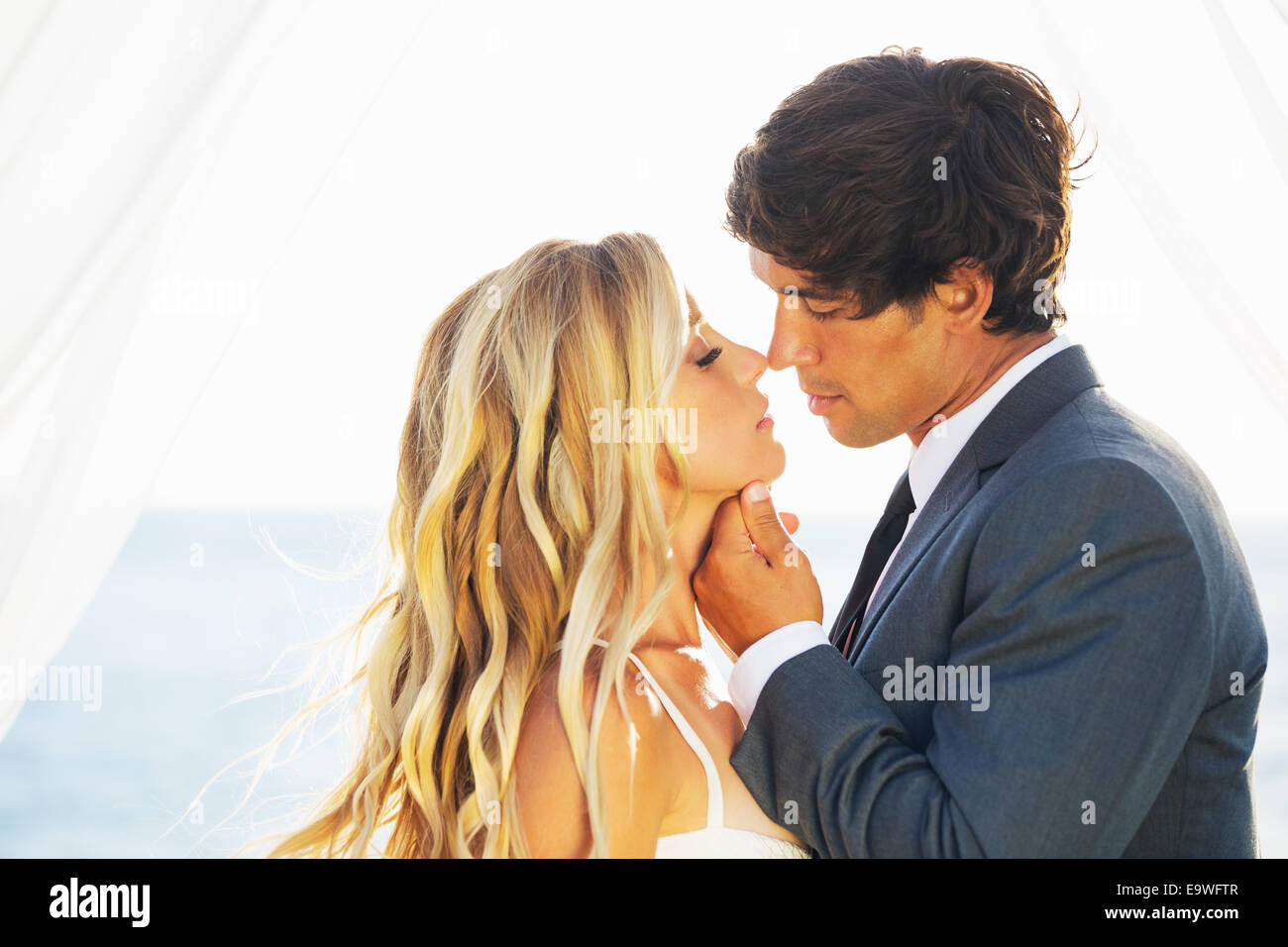 Hochzeit, schöne romantische Braut und Bräutigam küssen und umarmen bei Sonnenuntergang Stockfoto