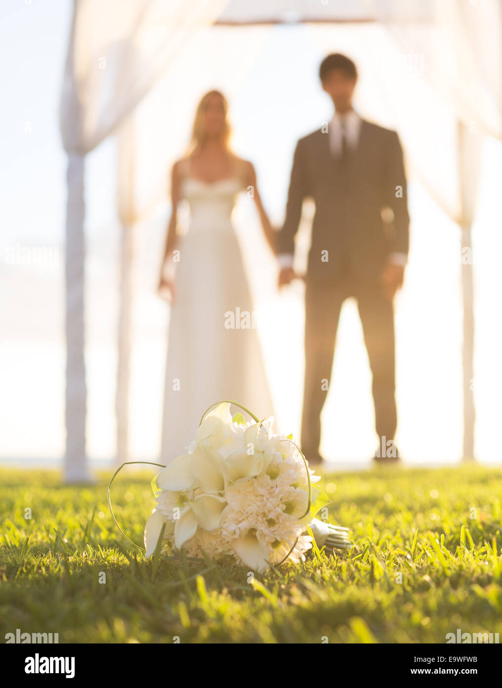 Hochzeit, schöne Braut und Bräutigam Hand in Hand. Schwerpunkt der Bouquet, geringe Schärfentiefe Stockfoto