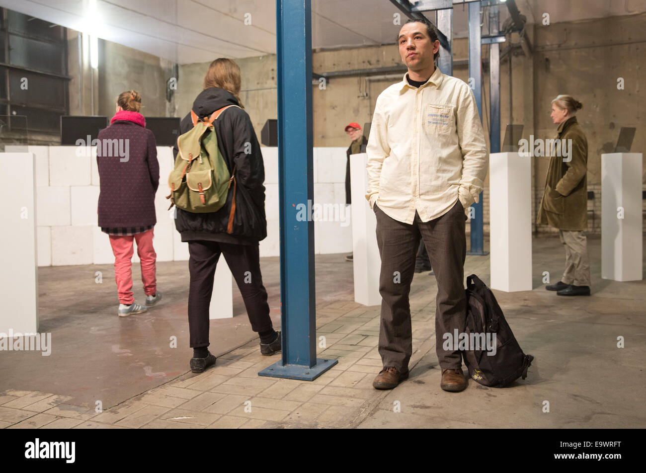 Berlin, Deutschland. 26. Oktober 2014. Die so genannte "stehender Mann" des Taksim Platzes, Erdem Gunduz (R) beteiligt sich das Performance-Projekt "Verhaltet Euch Ruhig" (Ruhe) am Kesselhaus Kunst Veranstaltungsort in Berlin, Deutschland, 26. Oktober 2014. Die Formiat Projekt Show Fällen Methoden, die die Möglichkeiten der Partizipation und Zuschauens, zivilen, gewaltfreien Widerstand und Kunst zu verbinden. Foto: Jörg Carstensen/Dpa/Alamy Live News Stockfoto