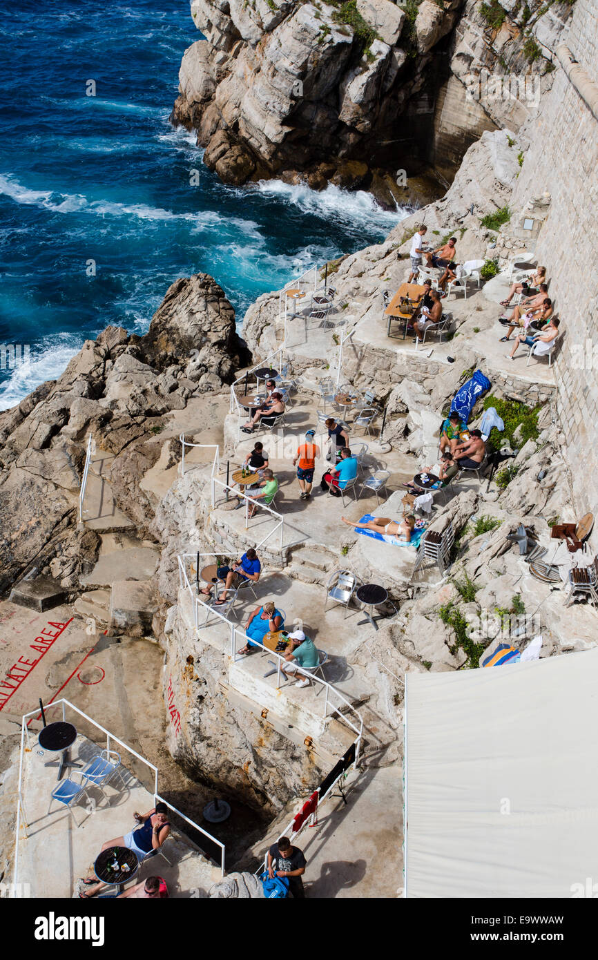 Touristen entspannen, sonnen und schwimmen Sie entlang der Stadtmauer in der Altstadt von Dubrovnik, Kroatien. Stockfoto