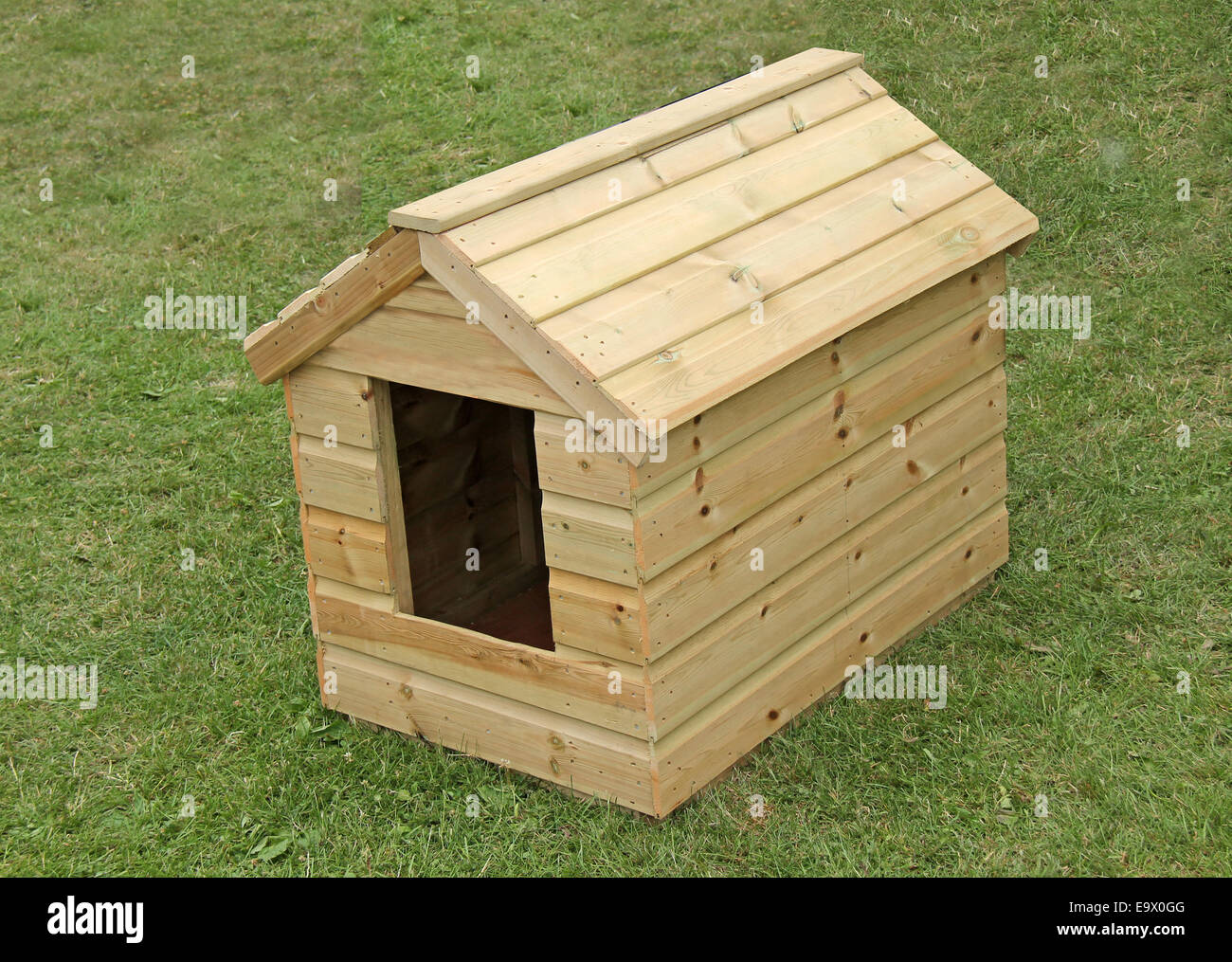 Eine neue hölzerne Hundehütte auf einem Rasen. Stockfoto