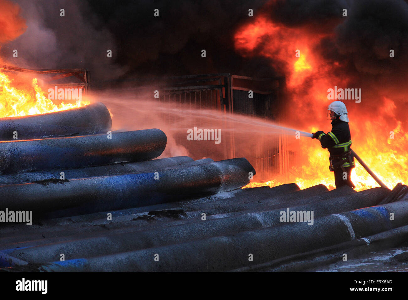 Feuerwehrleute versuchen zu lokalisieren ein Feuer als Leute zu beobachten und Fotografieren von Bon Feuer nach Explosion einer Tankstelle in der Stadt Vratca östlich der bulgarischen Hauptstadt Sofia, Donnerstag, 1. Mai 2014. Die Tankstelle explodiert nach einem schweren Gewitter in der Stadt. Ein Mann wurde verletzt, während des Vorfalls und der Zivilschutz Wache und Feuerwehrleute halten beobachten das Feuer. Foto von: Petar Petrov/Impact Press Group / mit: Bulgarien Tankstelle Feuer wo: Vratca, Bulgarien als: 1. Mai 2014 Stockfoto