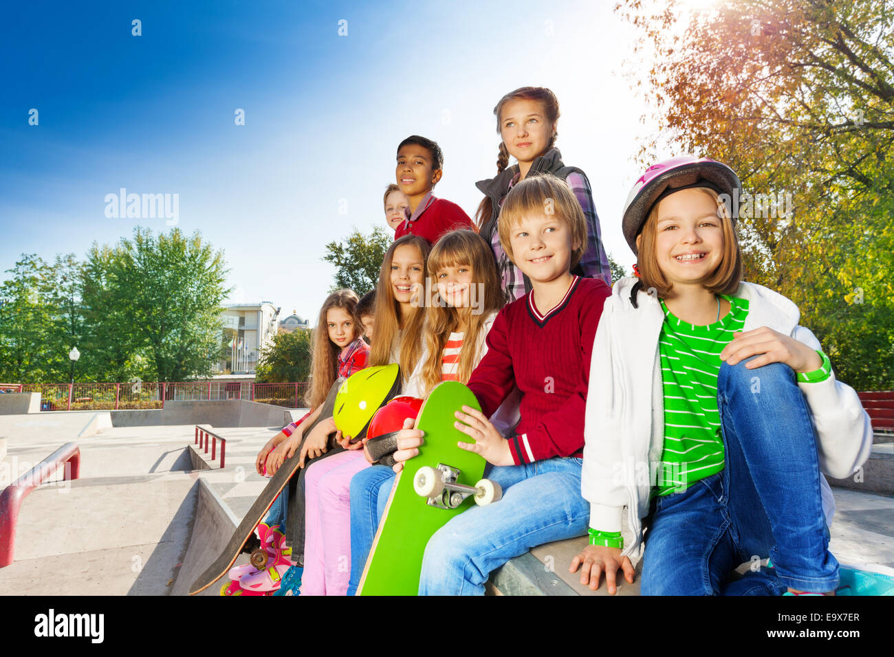 Viele Kinder mit Skateboards und Helme sitzen Stockfoto