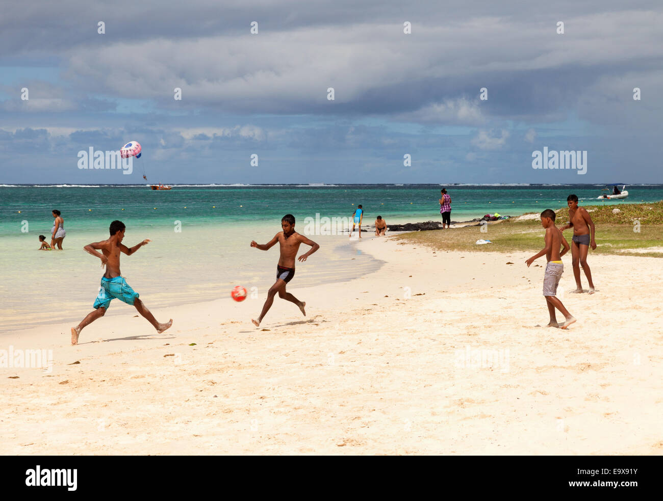 Mauritische Kinder und Jugendliche, die Fußball spielen auf der Strand, Belle Mare Beach, Ostküste Mauritius Stockfoto