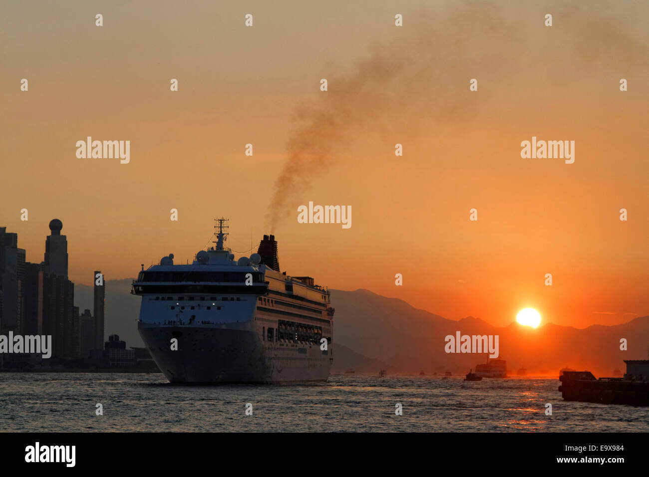 Ein Kreuzfahrtschiff fahren Hong Kong Hafen bei Sonnenuntergang. Stockfoto