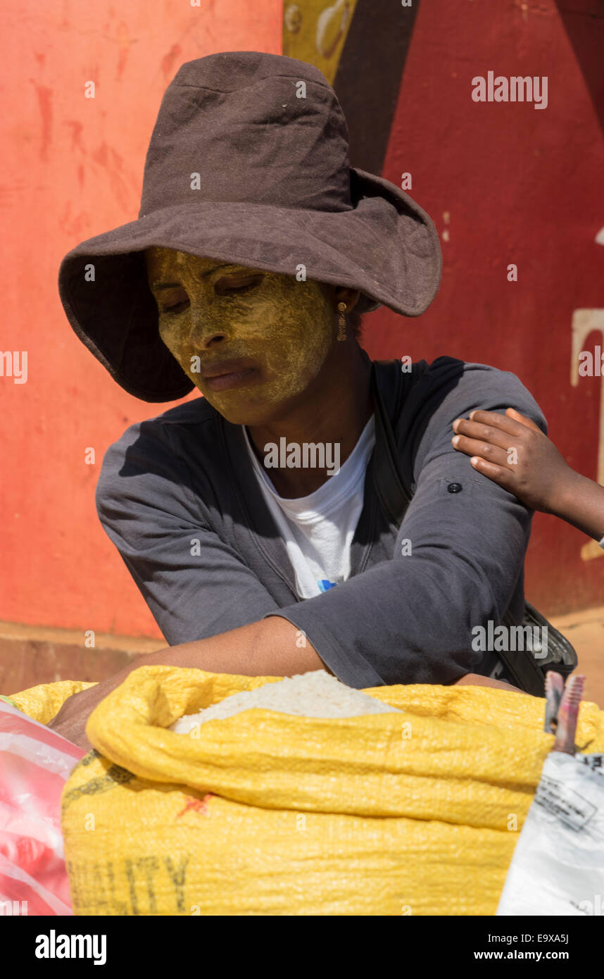 Ein traurig aussehende Markt Verkäufer in Madagaskar Verkauf von Lebensmitteln mit Kind an der hand Stockfoto