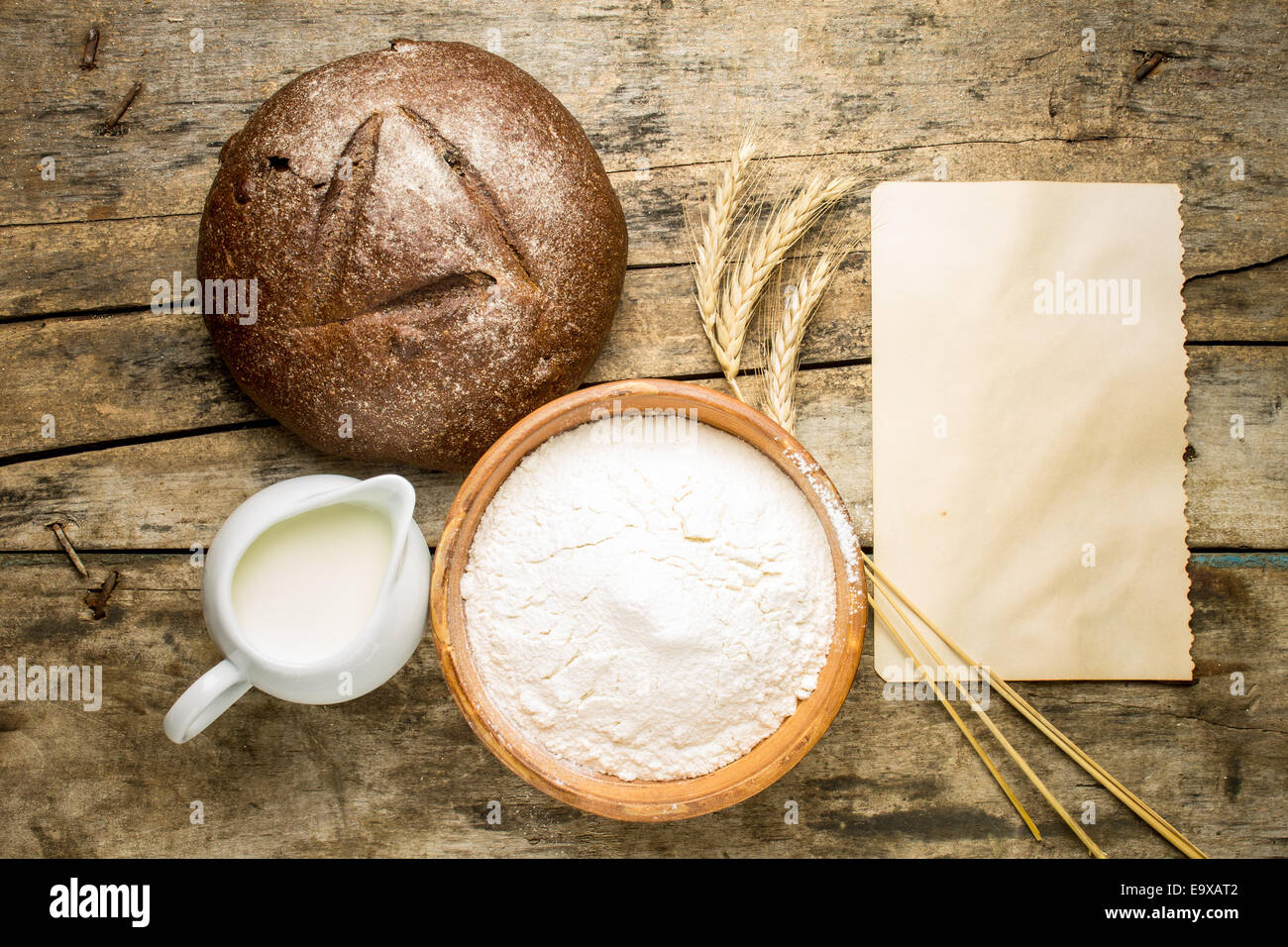 Bäckerei Rezept Hintergrund. Laib Roggenbrot mit Zutaten und leere Rezept Papier auf Holz Hintergrund Stockfoto