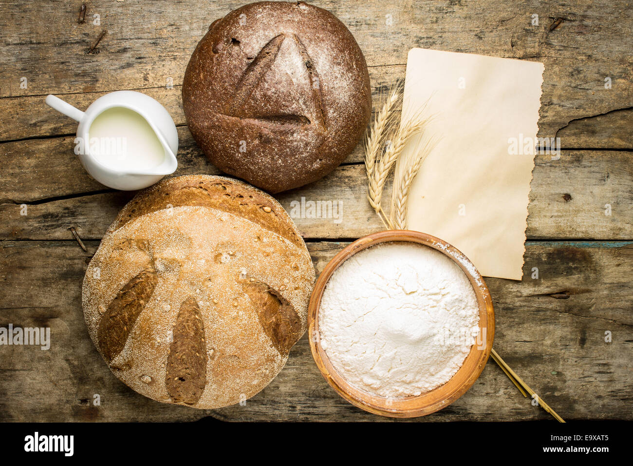 Verschiedene Brote Brot mit Backzutaten und leeren Papierbogen auf alten hölzernen Hintergrund Stockfoto