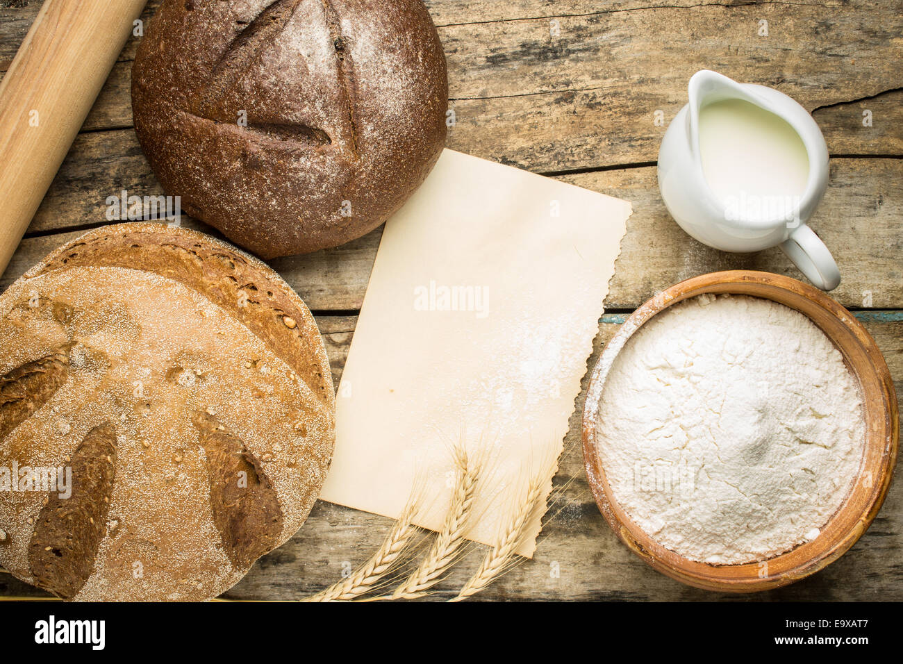 Backzutaten mit frischen Laib Brot und leeres Papierkarte für Rezept oder Menü. Stockfoto