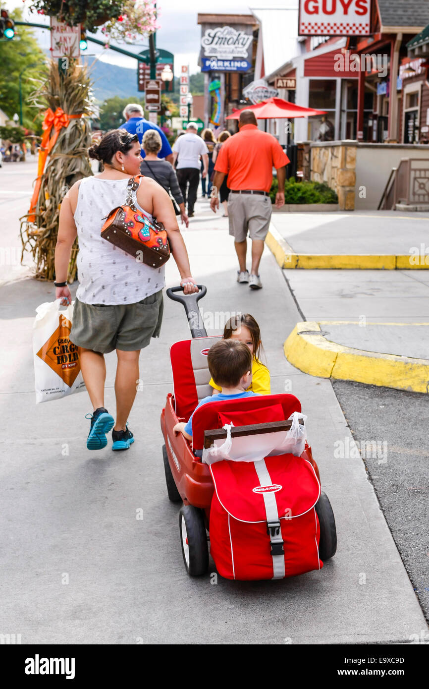 Eine Mutter ihre Kinder in einem Wagen ziehen geladen mit allem notwendigen für einen unterhaltsamen Tag im Gatlinburg, TN Stockfoto