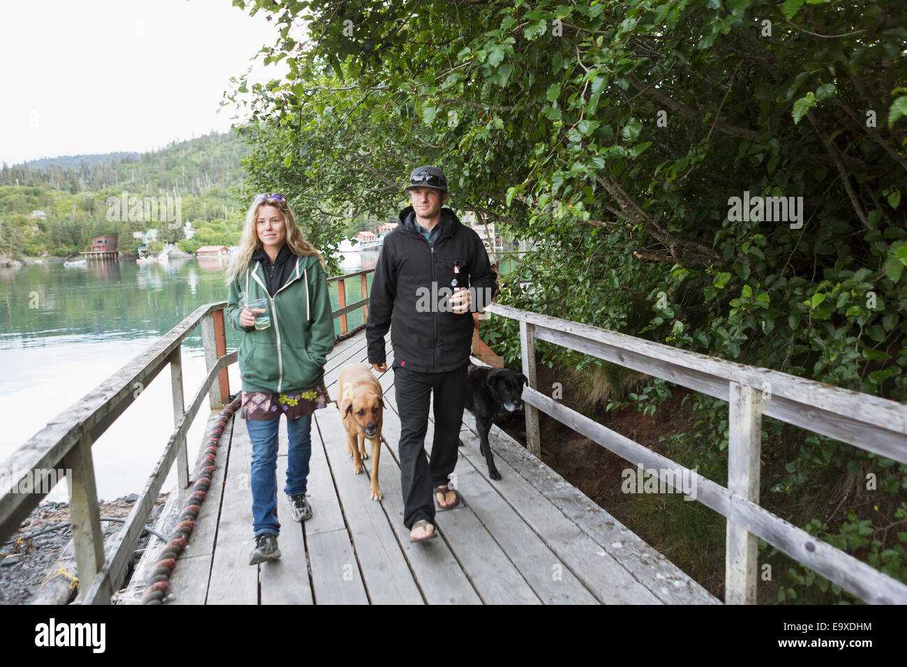 Paar Fuß mit ihrem Hund entlang der Promenade, Halibut Cove, Kachemak Bay, Yunan Alaska. Stockfoto