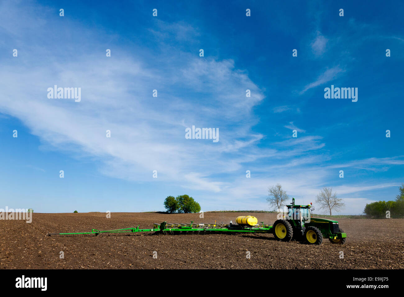 Landwirtschaft - ein John Deere Traktor und 24-reihig Pflanzer Pflanzen Mais in einem konventionell bebaute Feld / Minnesota, USA. Stockfoto