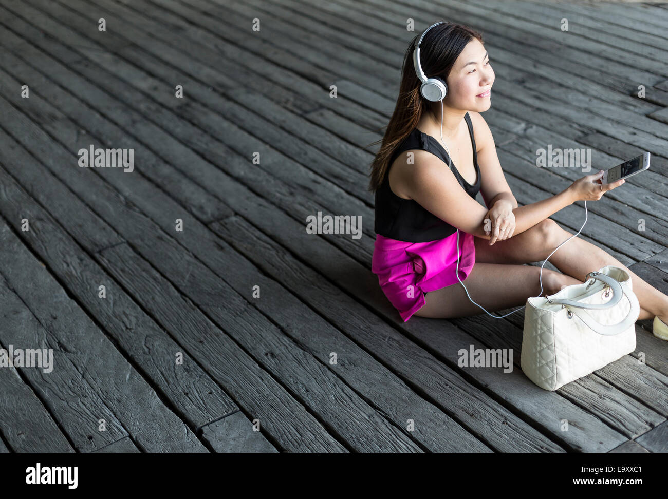 Eine junge Asiatin konsumieren von Inhalten auf ihr Smartphone im freien Stockfoto