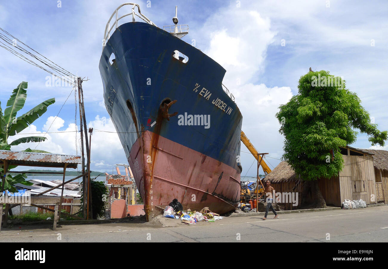 Ein gestrandetes Schiff beherrscht die Landschaft in Anibong, Philippinen, 26. Oktober 2014. Tausende von Filipinos verloren ihr Leben in den verheerenden Taifun Haiyan, die die Philippinen im Jahr 2013 getroffen. Auch heute noch leiden Überlebenden noch die Hinterlassenschaften der Katastrophe. Foto: Girlie Linao/dpa Stockfoto