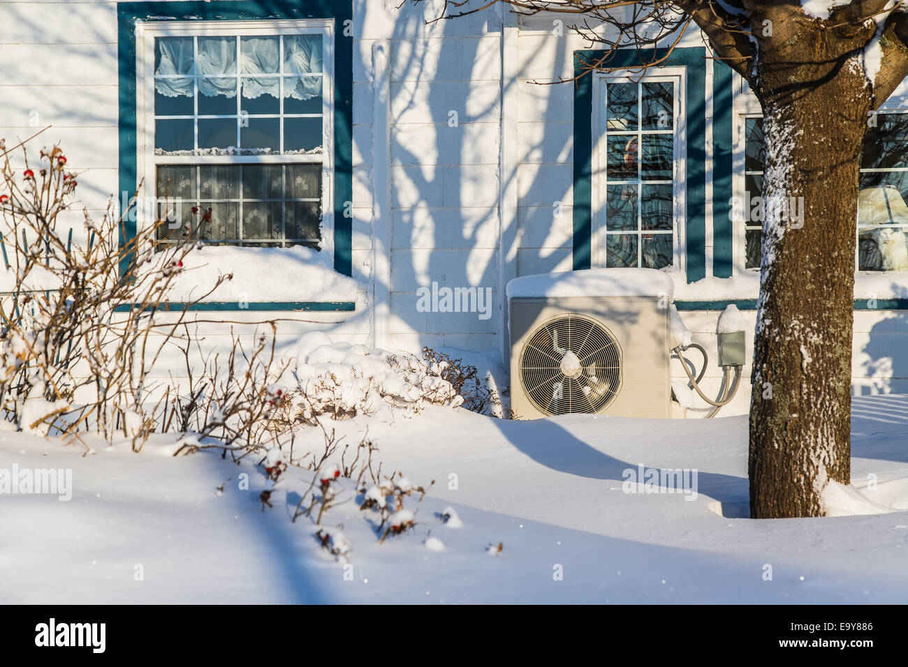 Wärmepumpe-Einheit an der Seite eines Hauses im Winter. Stockfoto