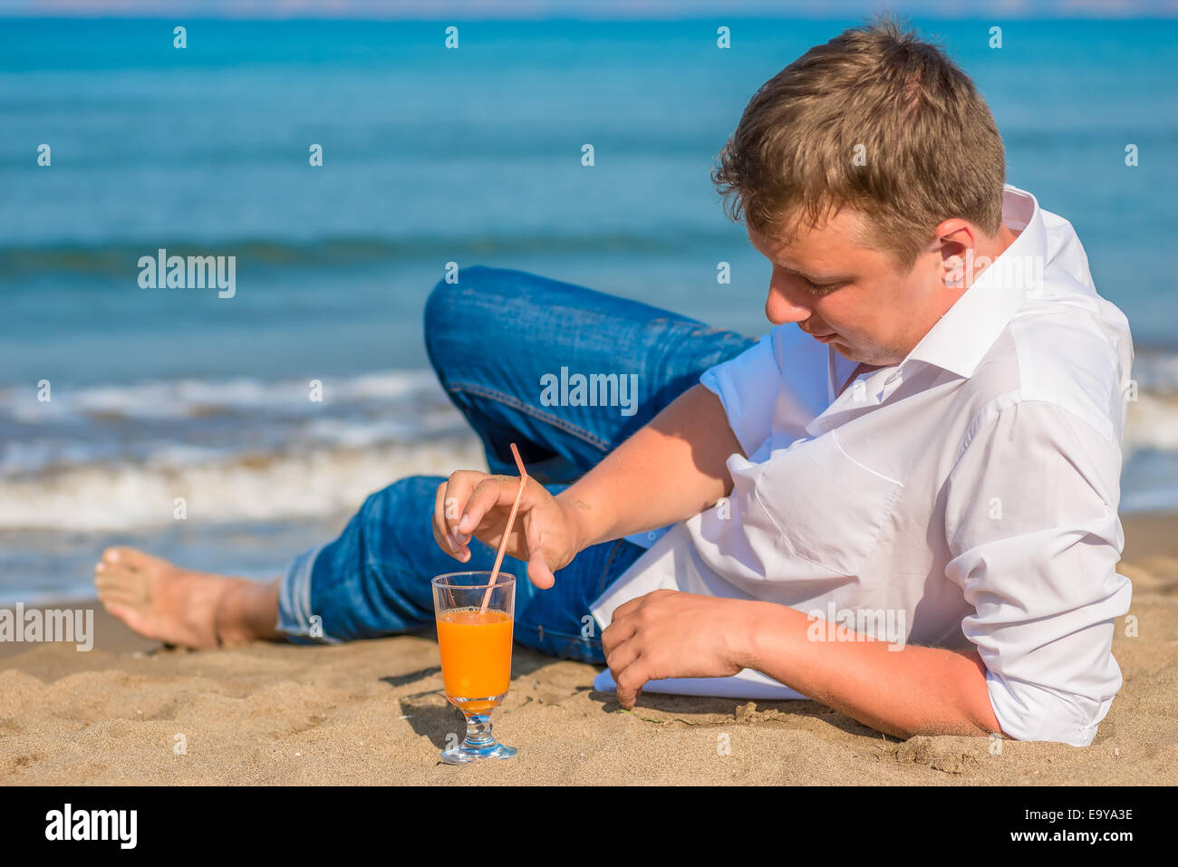erfolgreiche junge Mann Ruhe am Meer mit cocktail Stockfoto