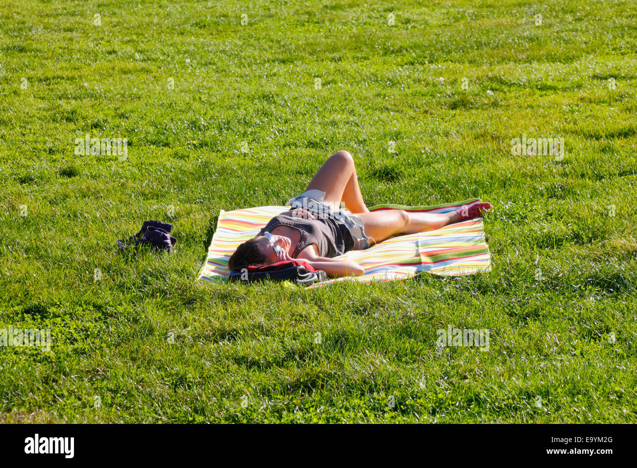 Junges Mädchen auf dem Rasen verlegen Stockfoto