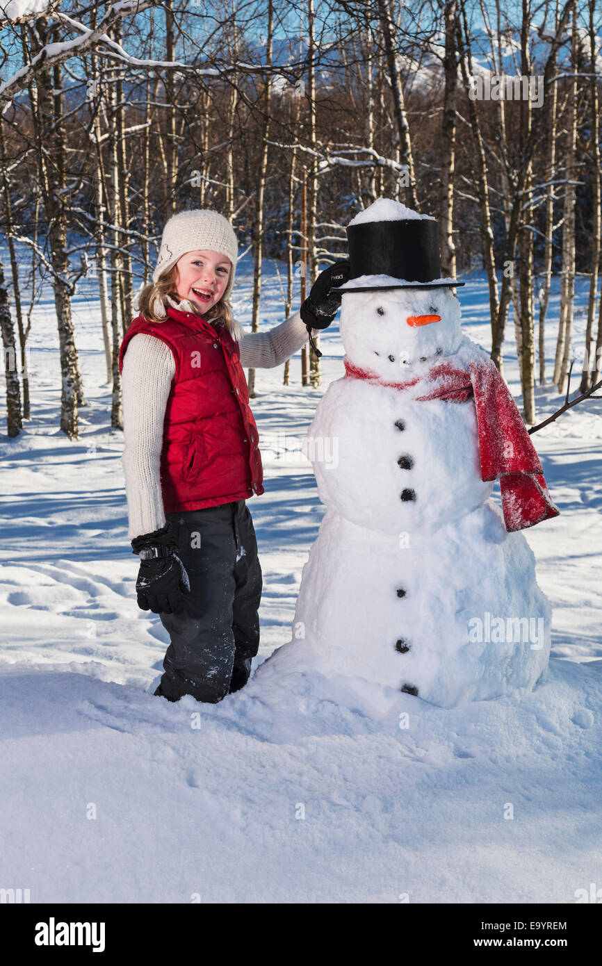Kaukasische Mädchen mit einem Schneemann Russisch Jack Springs Stadtpark, Anchorage, South Central Alaska, USA. Stockfoto