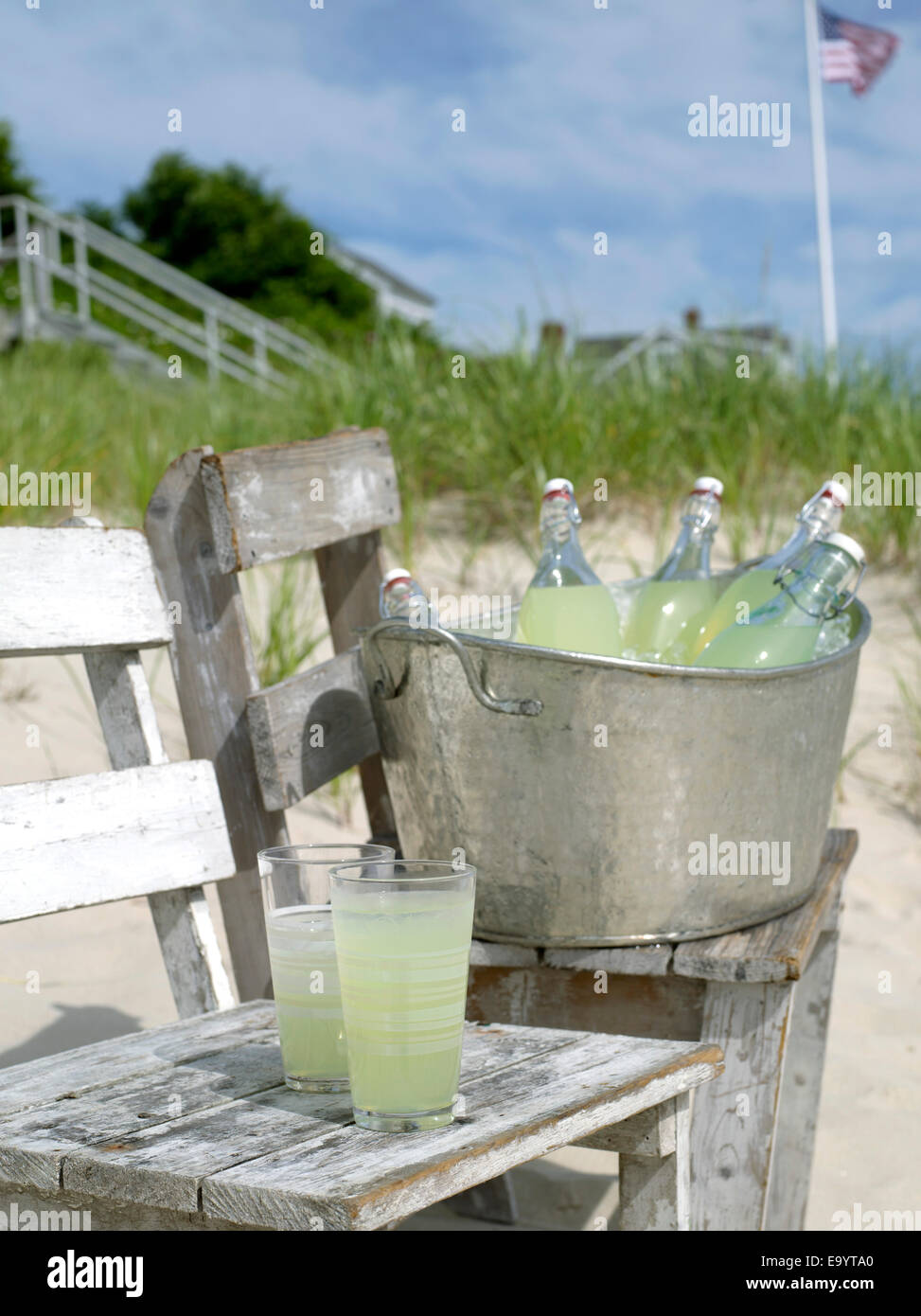 Gläser und Flaschen von Zitrone Aide am Strand Stockfoto