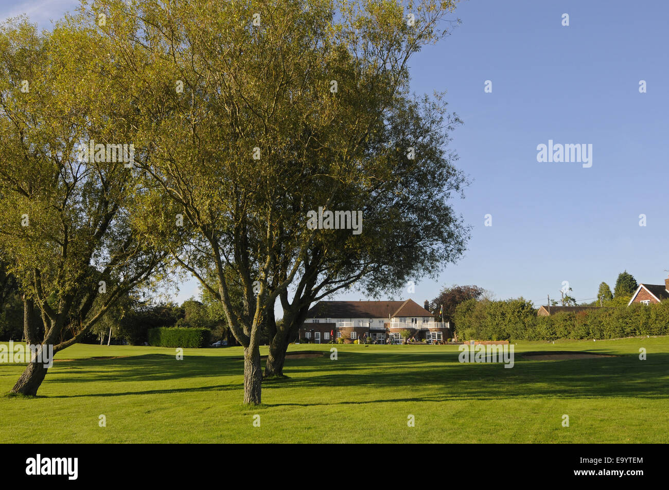 Blick durch die Bäume zum 18. Grün und Clubhaus Wrotham Heath Golf Club Sevenoaks Kent England Stockfoto