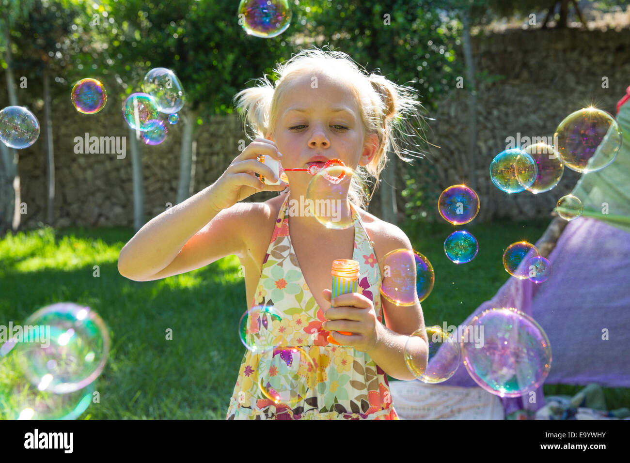 Mädchen bläst Seifenblasen in Sommer-Garten-party Stockfoto