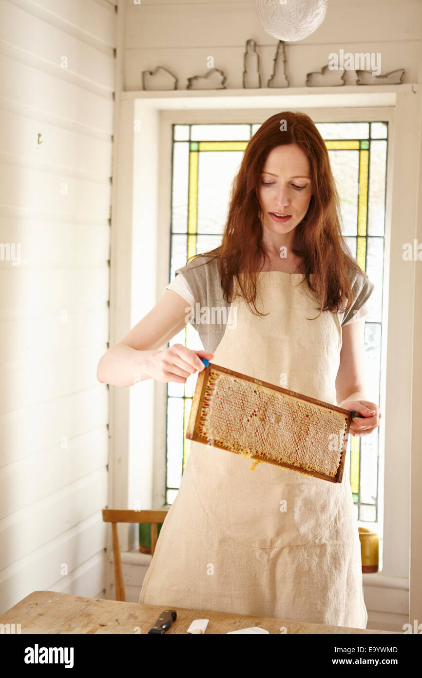 Weibliche Imker in Küche hält "Super" von Bienenstock (Honeycomb Tablett) Stockfoto