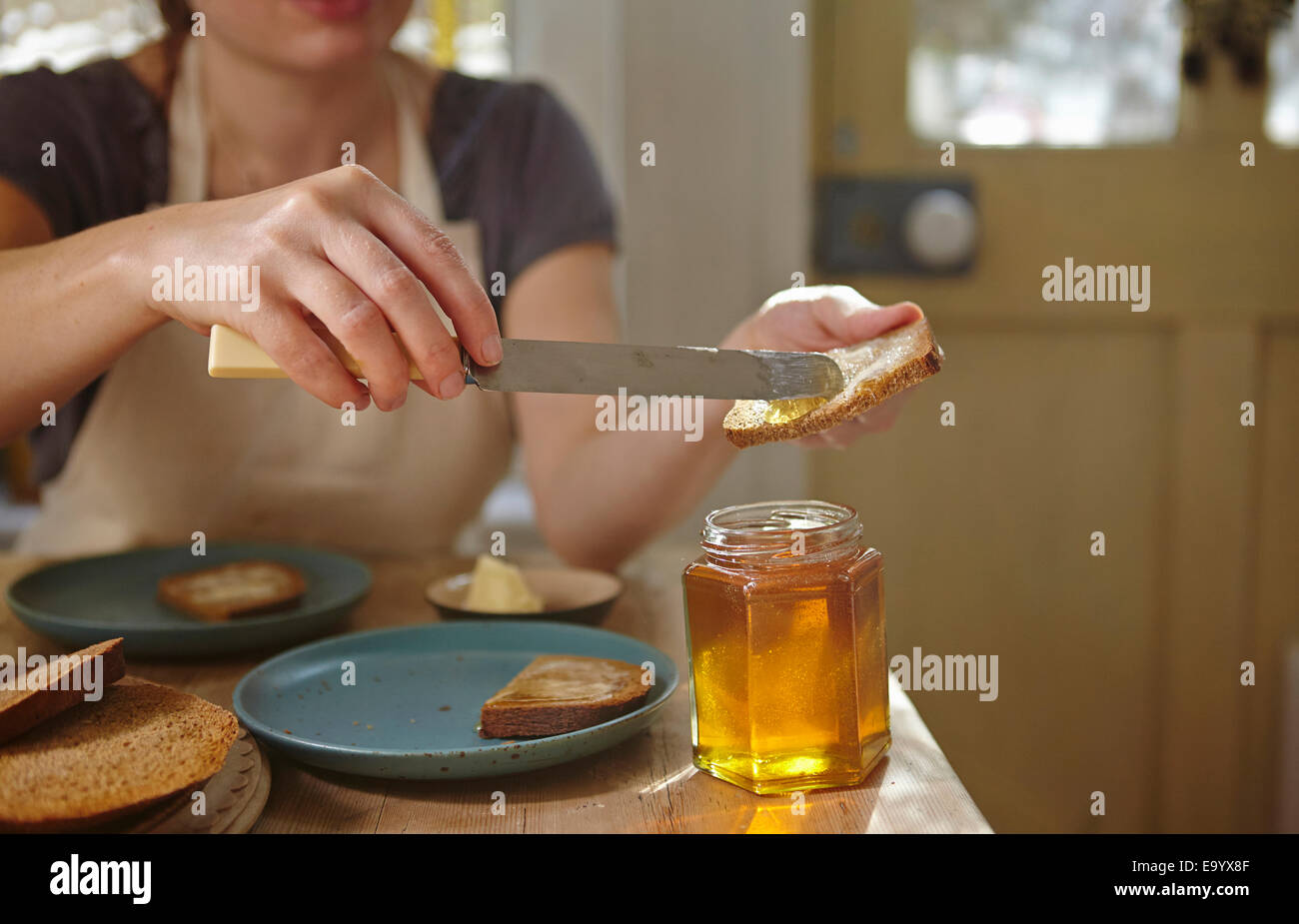 Frau frisch extrahierten Honig aufs Brot Verkostung Stockfoto