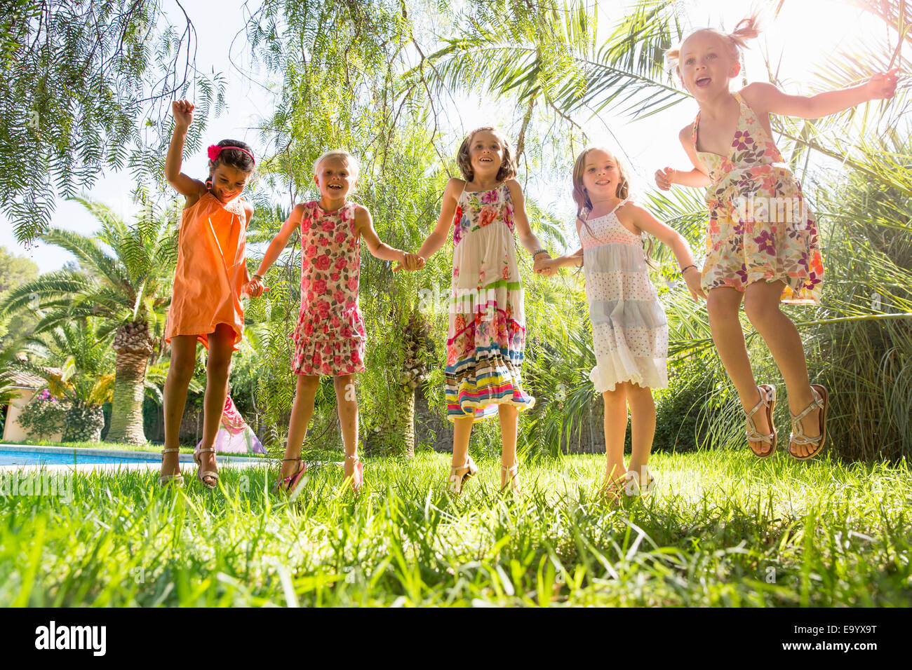 Fünf Mädchen energetische Mädchen springen im Garten Stockfoto