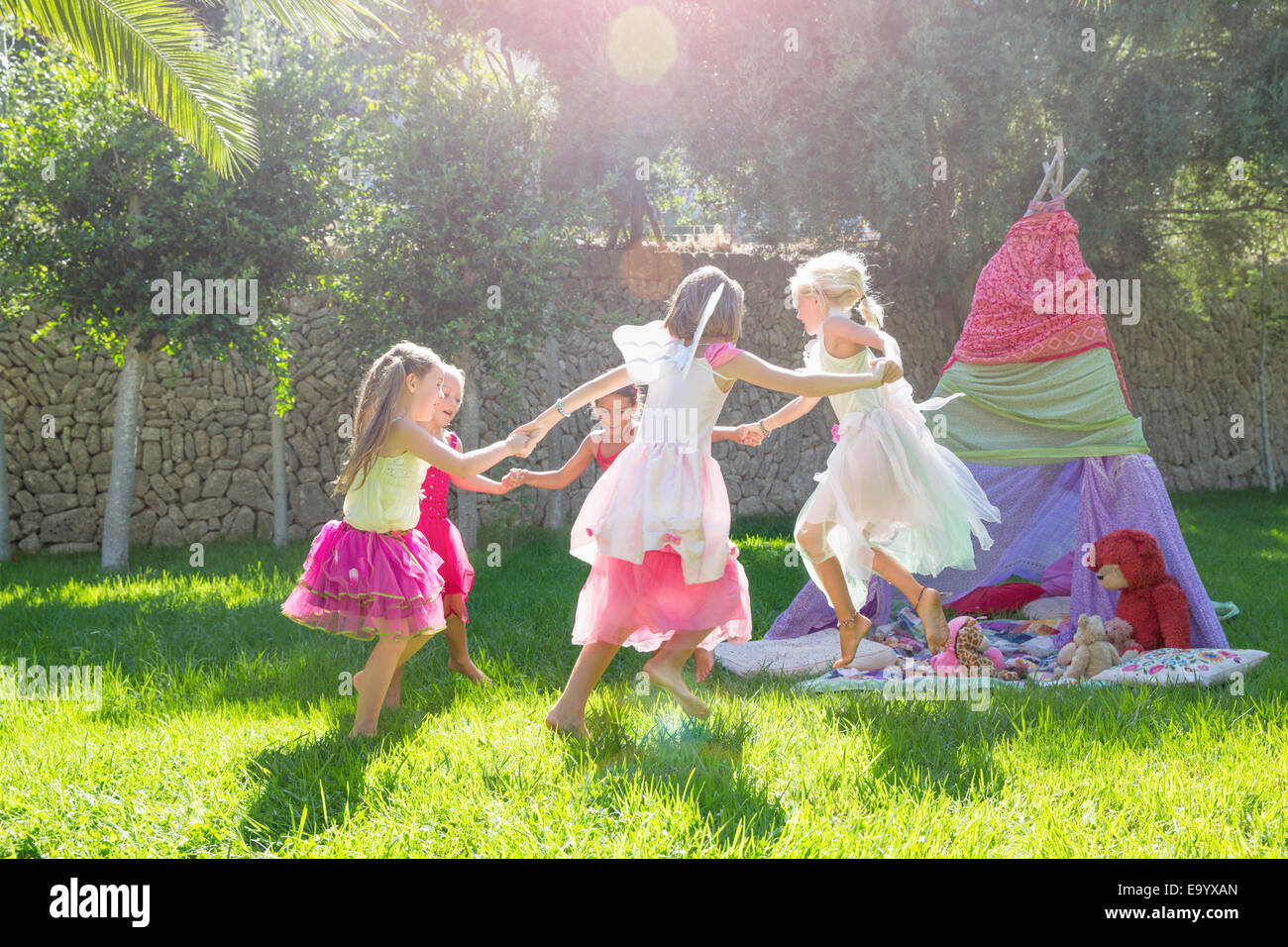 Fünf Mädchen in Fee Kostüm spielen im Garten Stockfoto