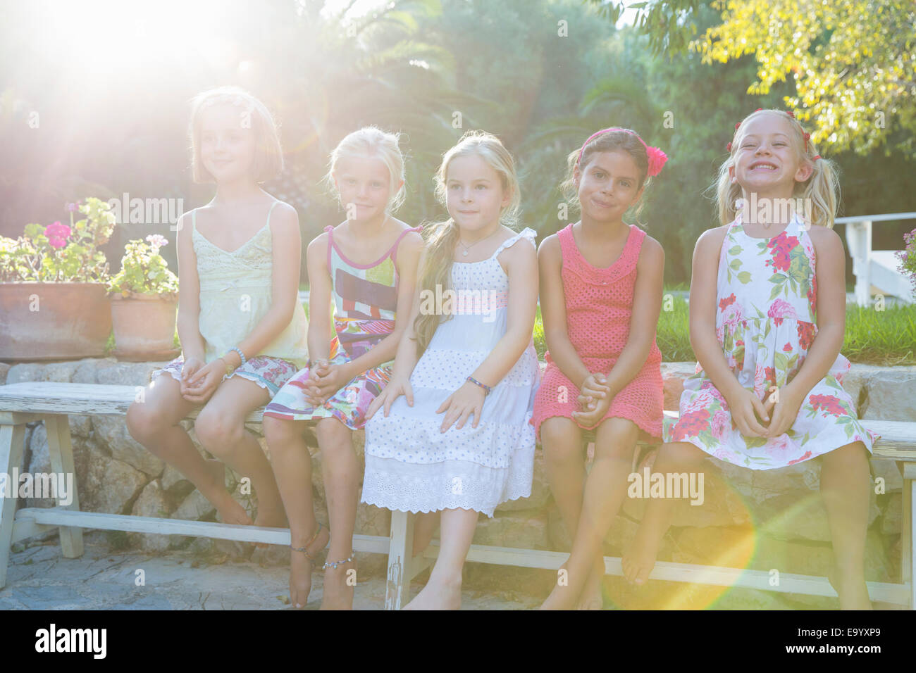 Porträt von fünf Mädchen sitzen auf Gartenbank Stockfoto