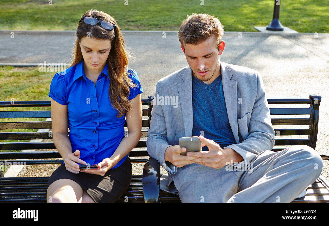 Geschäftsmann und Frau mit Smartphone im park Stockfoto