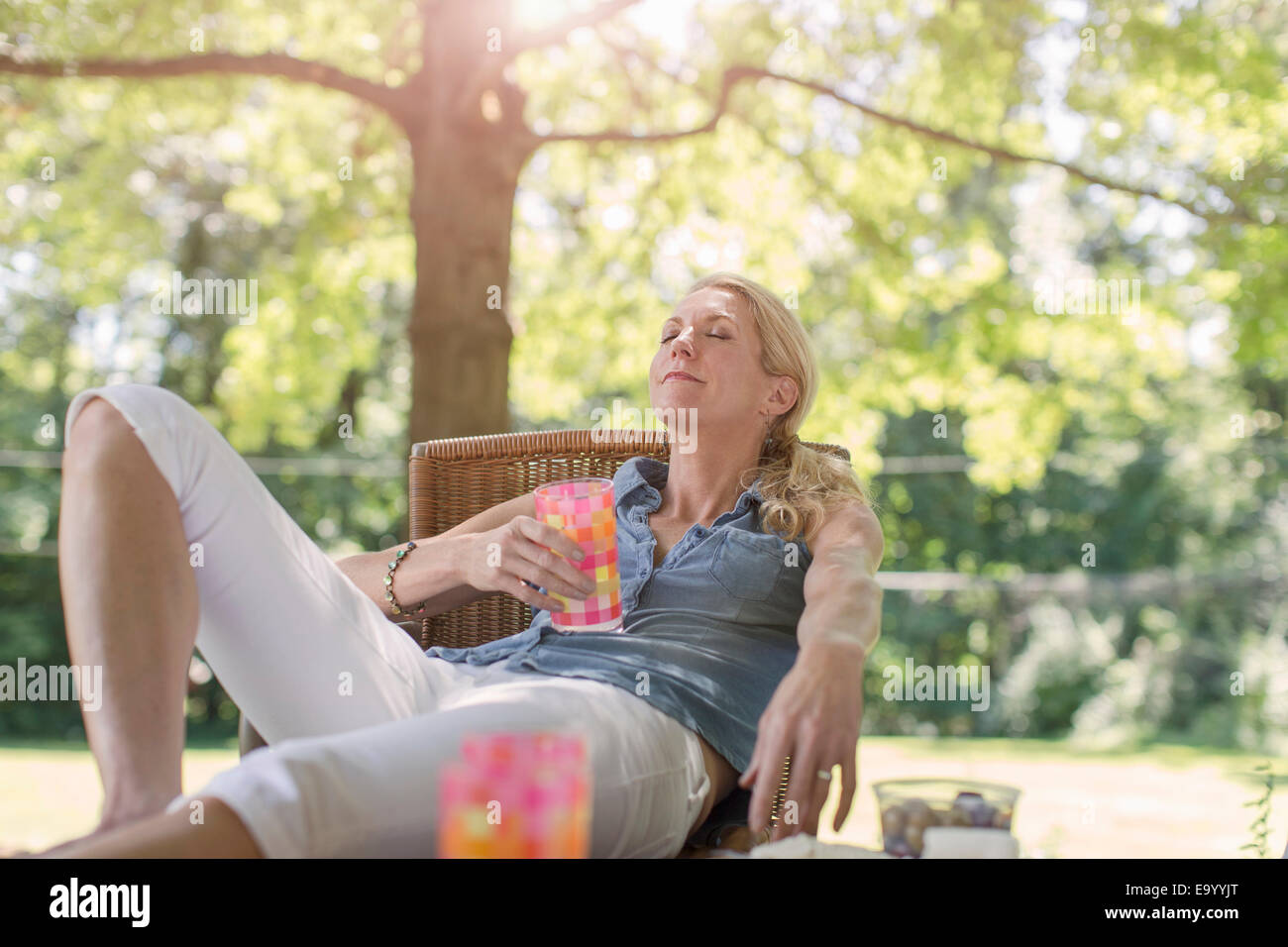 Reife Frau Entspannung im Garten mit Getränk Stockfoto