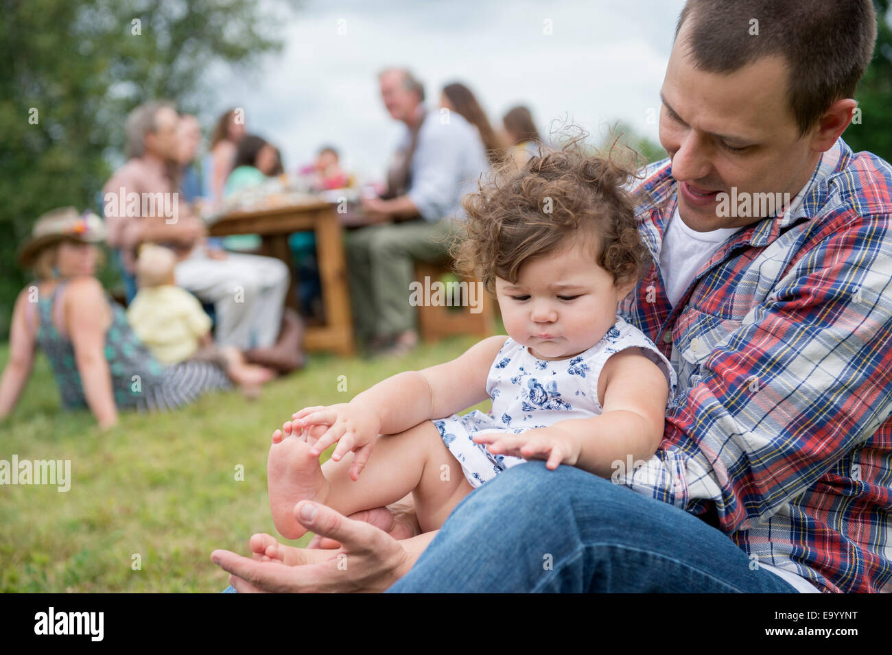 Vater mit Tochter bei Familientreffen, draußen spielen Stockfoto