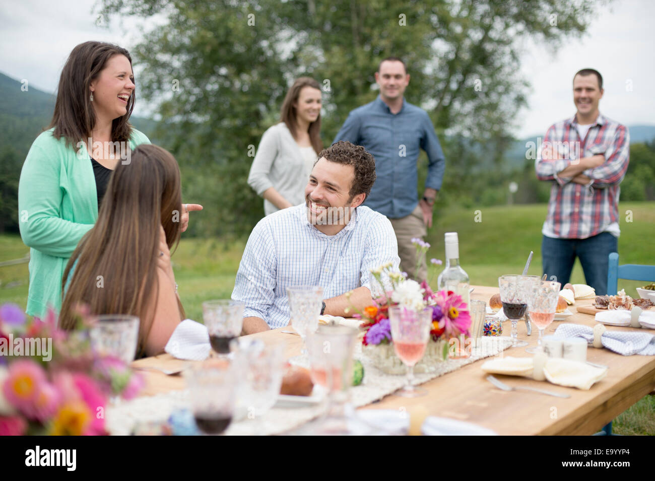 Familie und Freunde versammelten sich um, sprechen, am Ende einer Mahlzeit im freien Stockfoto